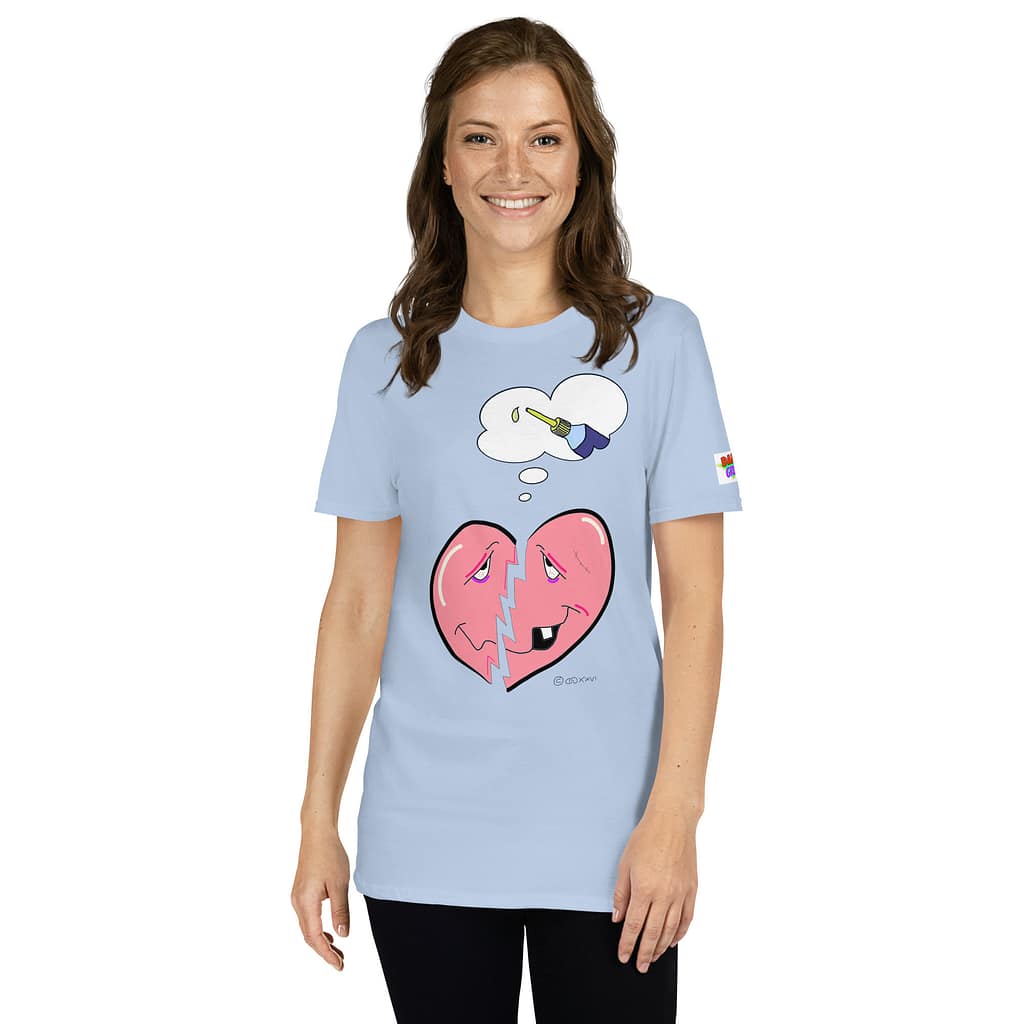 Caucassian looking brunette with smiling into camera wearing a light-blue Daddy Grunge- handdrawn graphic tee showing a cartoon-style broken heart-shaped smiley who is thinking he has a glue to fix it