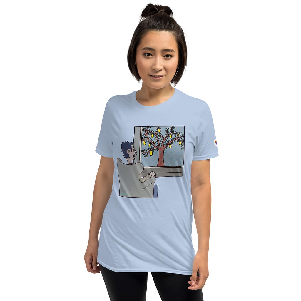 Asian girl looking straight into the camera wearing a light blue emo T-shirt of Daddy grunge showing a cartoon of a moody guy sitting in a chair and looking out into the gloomy, rainy weather where outside a tree with lemons stands.