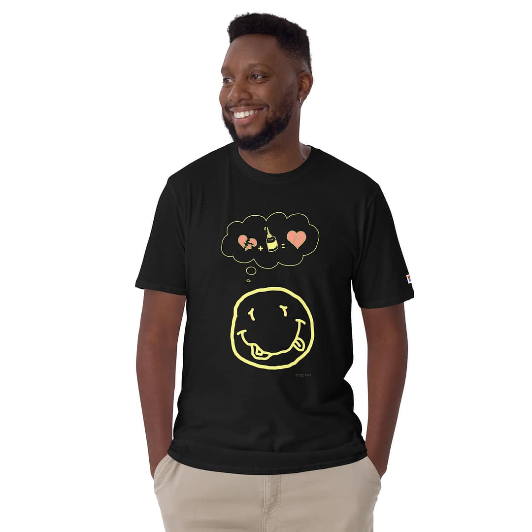 Smiling black guy in a black daddy grunge cartoon shirt with the altered Nirvana smiley and the thought bubble with the glued together heart pieces as a motive.