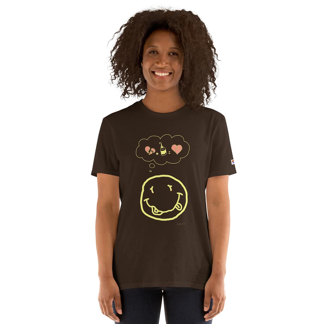 Dark-skinned girl in a dark brown daddy grunge cartoon shirt with the altered Nirvana smiley and the thought bubble with the glued together heart pieces as a motive.