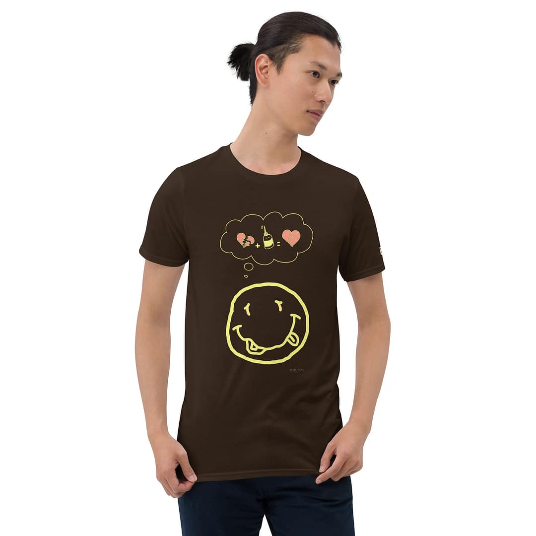 Skinny Asian guy in a dark brown daddy grunge cartoon shirt with the altered Nirvana smiley and the thought bubble with the glued together heart pieces as a motive.