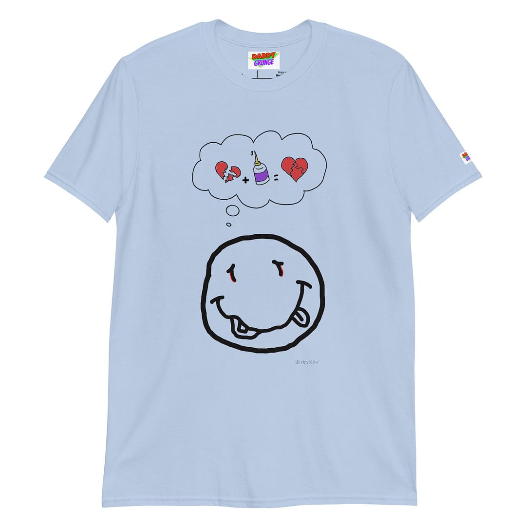 Picture with a bright blue colored shirt with a cartoonish yellow smiley resembling the Nirvana smiley who has a a thought bubble showing a broken heart with a glue squeeze bottle which connects the broken pieces to a repaired heart with the pieces glued together