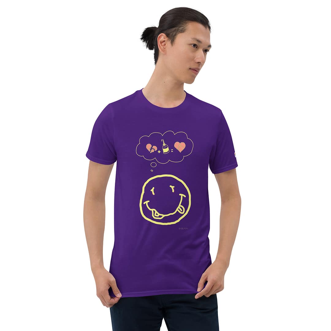 Skinny Asian guy with a man bun in a purple daddy grunge cartoon shirt with the altered Nirvana smiley and the thought bubble with the glued together heart pieces as a motive.