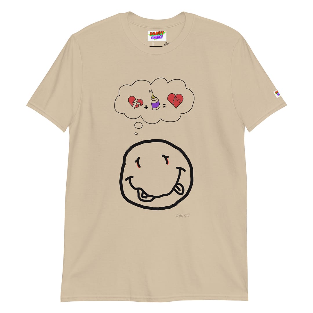 Picture with a sand colored shirt with a cartoonish yellow smiley resembling the Nirvana smiley who has a a thought bubble showing a broken heart with a glue squeeze bottle which connects the broken pieces to a repaired heart with the pieces glued together
